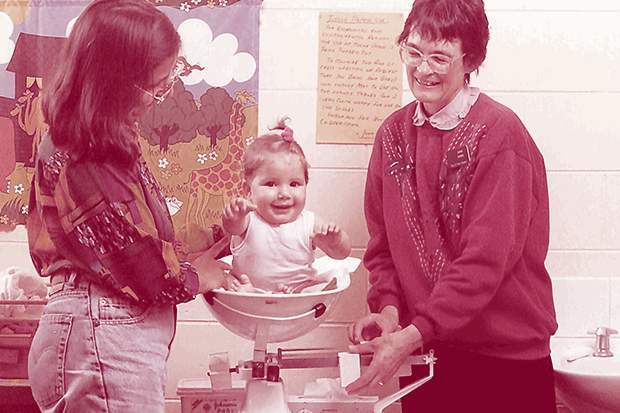 Baby gets weighed by maternal and child health nurse Jan Shaddock, 1995. Courtesy of the Public Record Office Victoria.