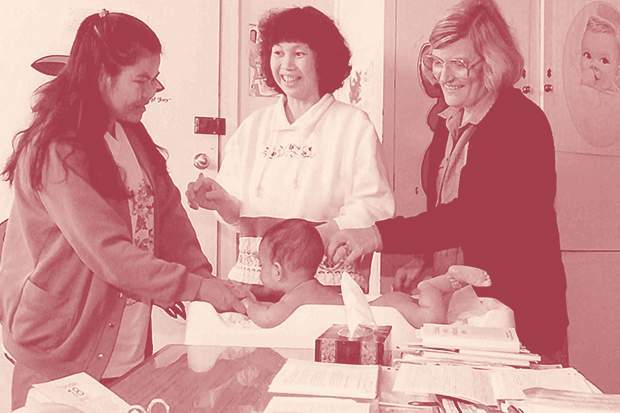 Baby in consultation with maternal and child health nurse, with help from an interpreter, 1995. Courtesy of the Public Record Office Victoria.